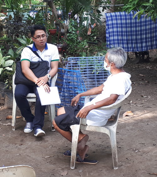Mr. Adrian Hort Ramos, Region VI technical staff, talks to a TB patient during a home monitoring visit.
